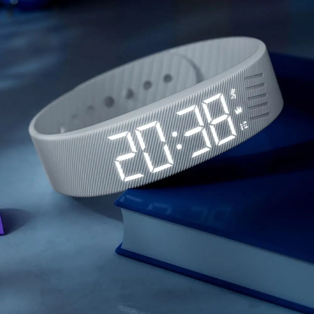 WristWake alarm band on a bedside book
